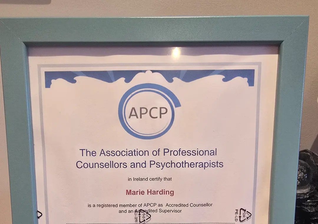 A framed APCP certificate for Marie Harding, displayed in the counselling room.