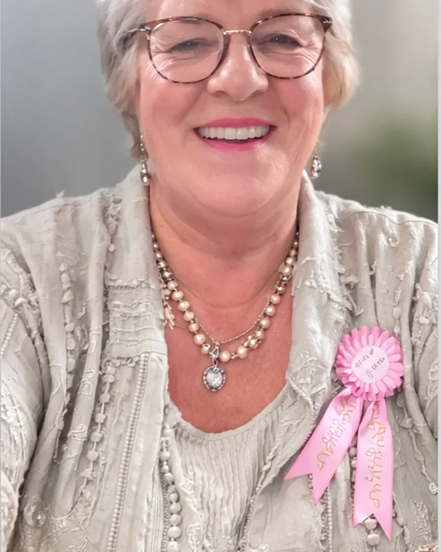 Marie Harding smiling in a light blouse and glasses.